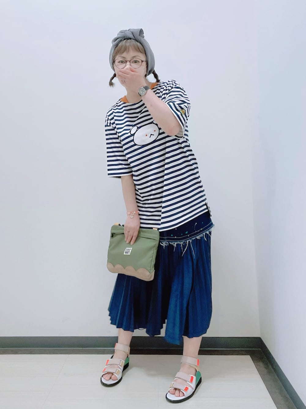 ホワイト系のトップス、グリーン系のショルダーバッグ、ブルー系のスカートを着用したレディースの夏コーディネートの2枚目の写真