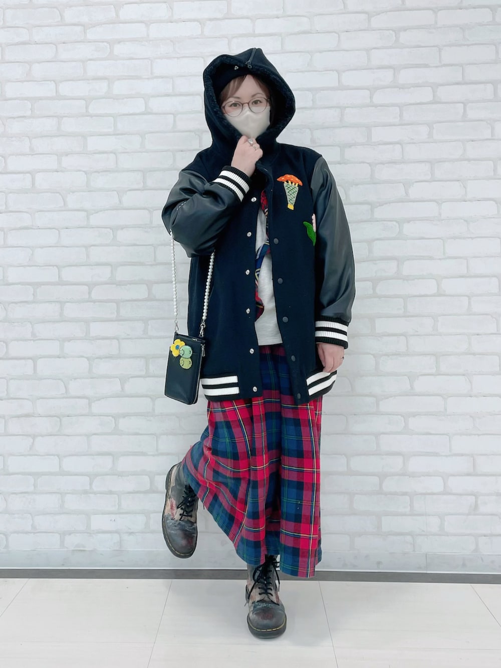 ブラック系のスタジャン、ホワイト系のTシャツ/カットソー、ブラック系のショルダーバッグを着用したレディースの冬コーディネートの3枚目の写真