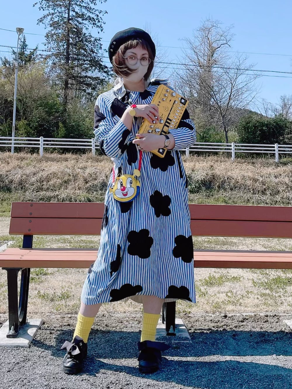 イエロー系のバッグ、ブルー系のワンピース/ドレス、ブラック系のシューズを着用したレディースの春コーディネートの2枚目の写真