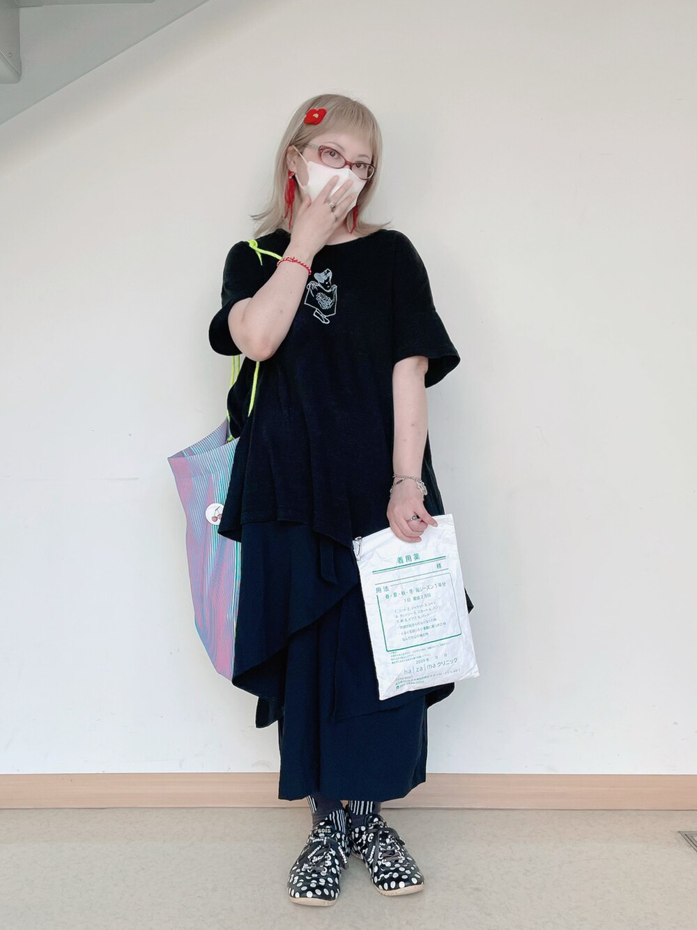 ブルー系のトートバッグ、ブラック系のTシャツ/カットソー、ブラック系のスニーカーを着用したレディースの夏コーディネートの2枚目の写真