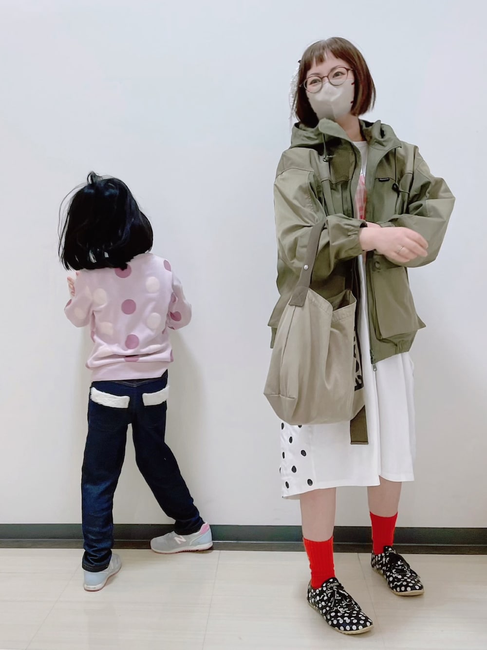 グリーン系のマウンテンパーカー、ホワイト系のワンピース、グレー系のエコバッグ/サブバッグを着用したレディースの春コーディネートの3枚目の写真