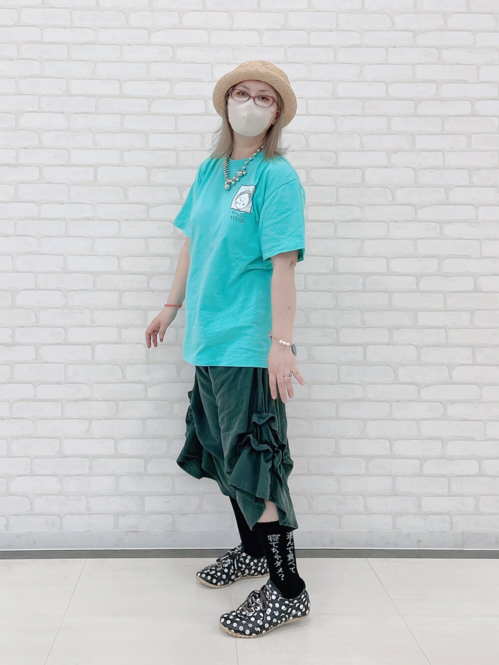 グリーン系のTシャツ/カットソー、グレー系のその他パンツ、ブラック系のスニーカーを着用したレディースの夏コーディネートの2枚目の写真