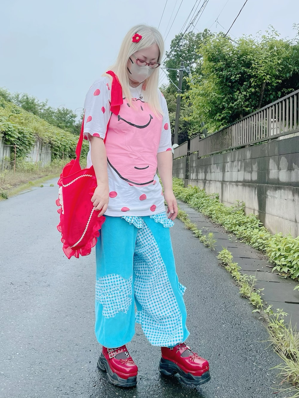レッド系のショルダーバッグ、レッド系のスニーカー、ピンク系のトップスを着用したレディースの夏コーディネートの3枚目の写真