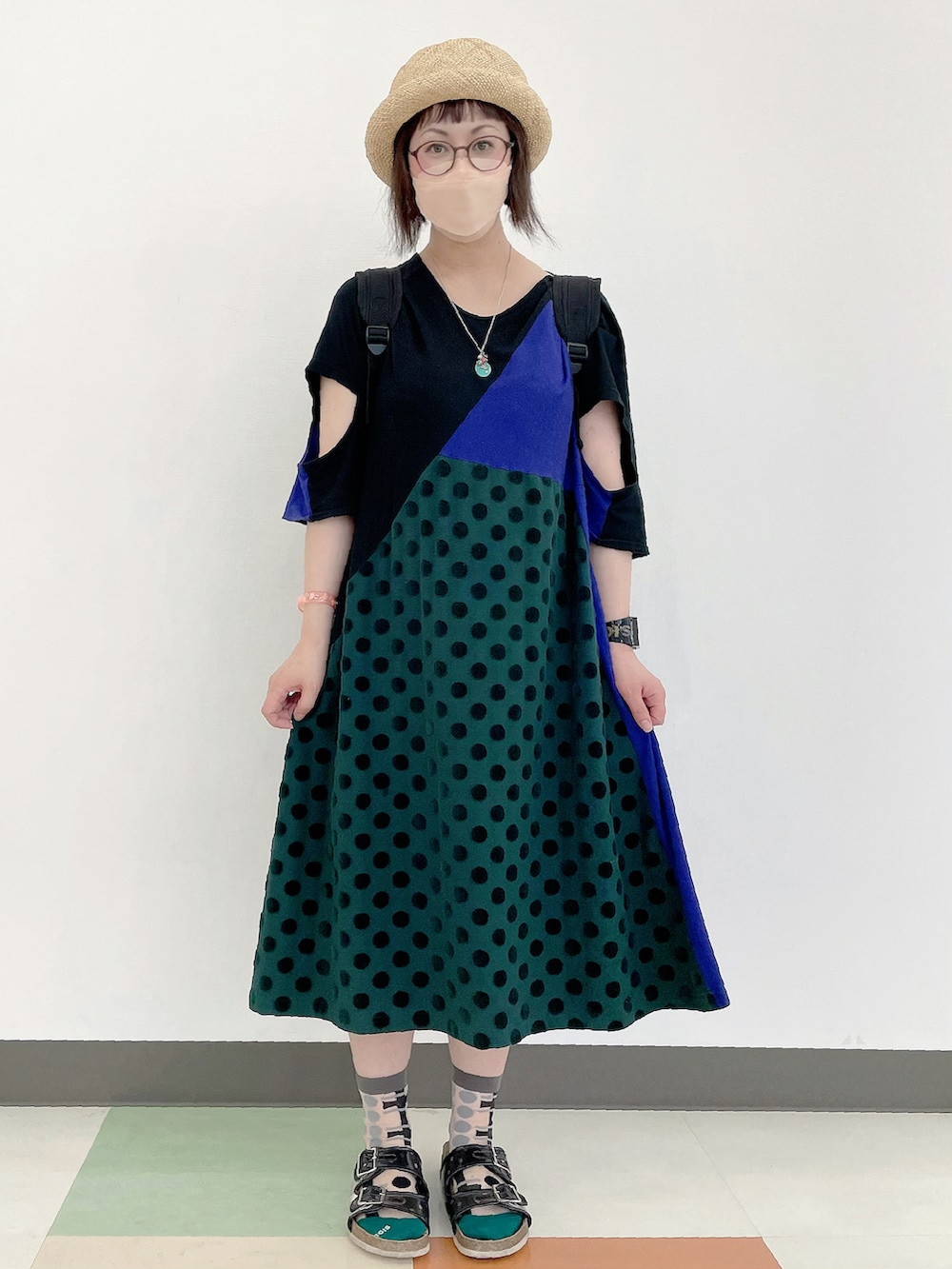 パープル系のワンピース、ブラック系のバックパック/リュック、ブラック系のサンダルを着用したレディースの夏コーディネートの2枚目の写真