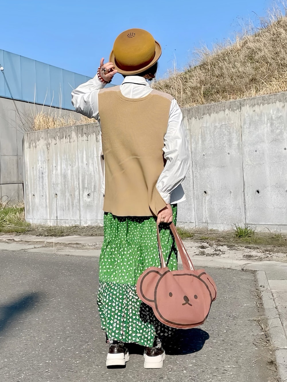 グリーン系のネクタイ、ベージュ系のベスト、ホワイト系のシャツ/ブラウスを着用したレディースの春コーディネートの2枚目の写真