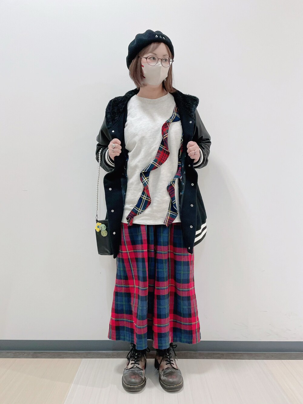 ブラック系のスタジャン、ホワイト系のTシャツ/カットソー、ブラック系のショルダーバッグを着用したレディースの冬コーディネートの2枚目の写真