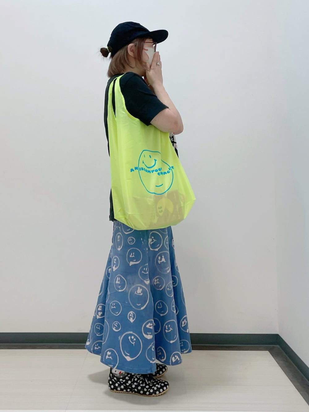 ブラック系のTシャツ/カットソー、グリーン系のバッグ、ブルー系のデニムスカートを着用したレディースの秋コーディネートの2枚目の写真