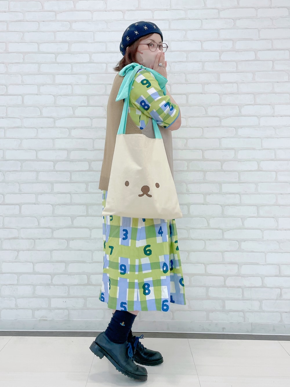 ブルー系のワンピース、ホワイト系のTシャツ/カットソー、ブラック系のスカートを着用したレディースの冬コーディネートの4枚目の写真