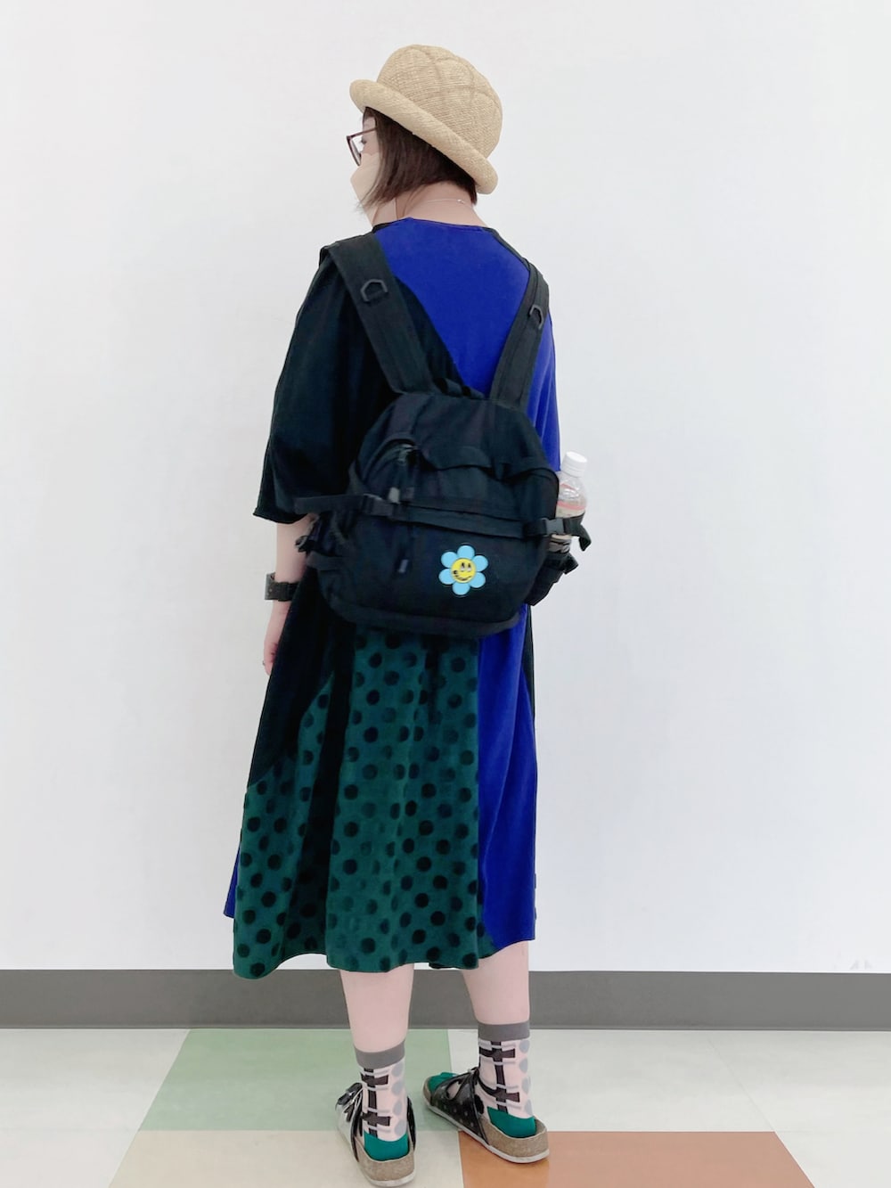 パープル系のワンピース、ブラック系のバックパック/リュック、ブラック系のサンダルを着用したレディースの夏コーディネートの3枚目の写真