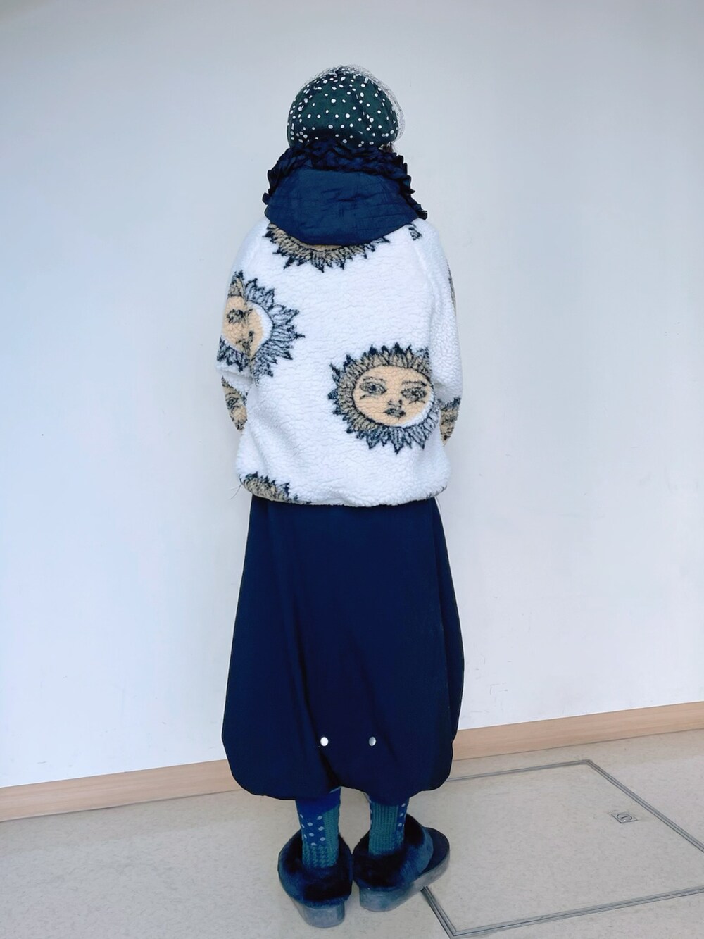 ホワイト系のトップス、グリーン系のショルダーバッグ、ブラック系のスカートを着用したレディースの冬コーディネートの3枚目の写真