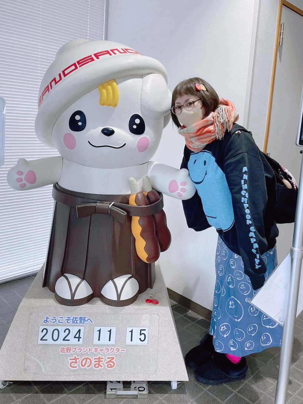 ブラック系のスウェット、ブラック系のバックパック/リュック、ブルー系のデニムスカートを着用したレディースの秋コーディネートの2枚目の写真