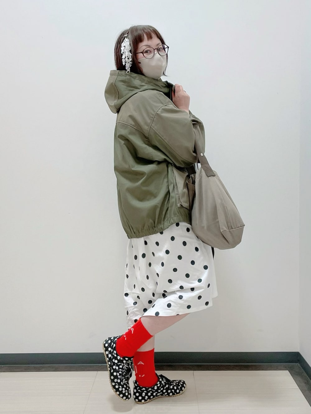 グリーン系のマウンテンパーカー、ホワイト系のワンピース、グレー系のエコバッグ/サブバッグを着用したレディースの春コーディネートの2枚目の写真