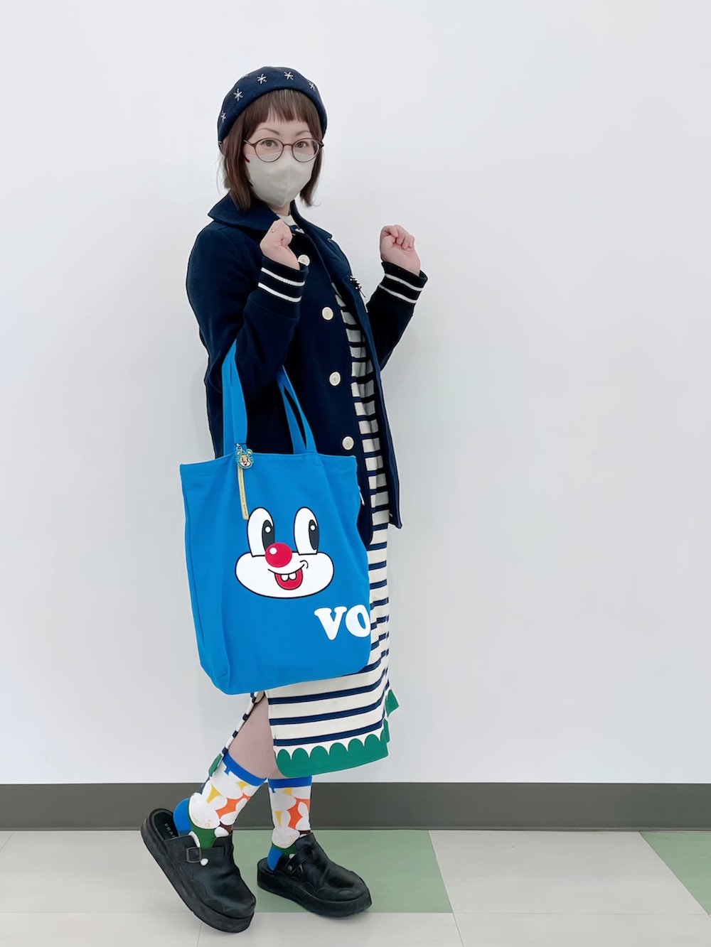 ブルー系のピーコート、ホワイト系のワンピース、ブルー系のトートバッグを着用したレディースの春コーディネートの3枚目の写真