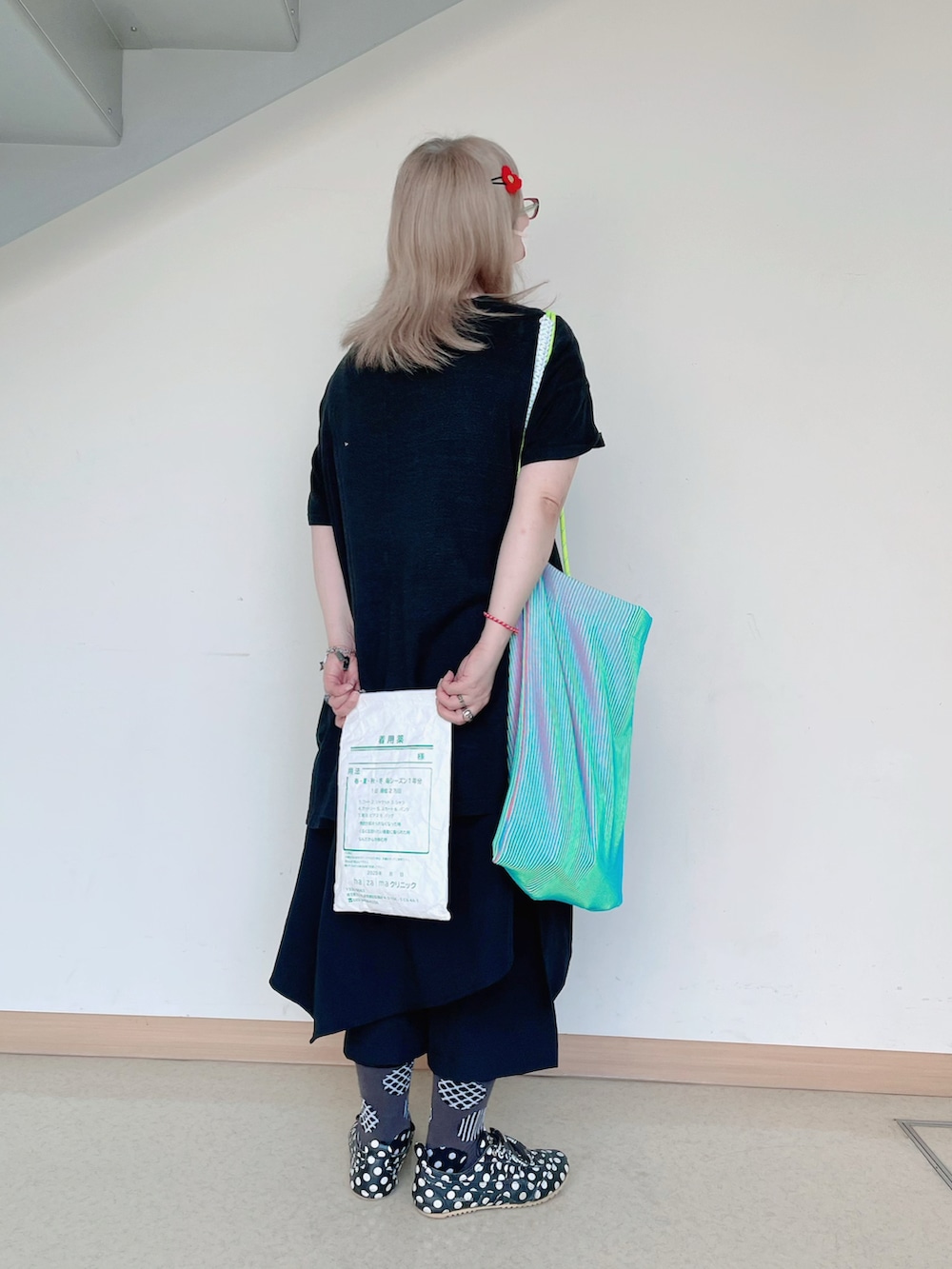 ブルー系のトートバッグ、ブラック系のTシャツ/カットソー、ブラック系のスニーカーを着用したレディースの夏コーディネートの3枚目の写真