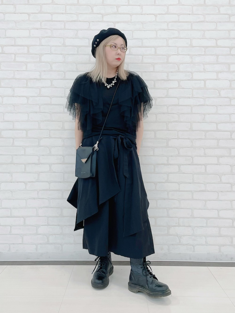 ブラック系のトップス、ブラック系のパンツ、ブラック系のバッグを着用したレディースの秋コーディネートの2枚目の写真