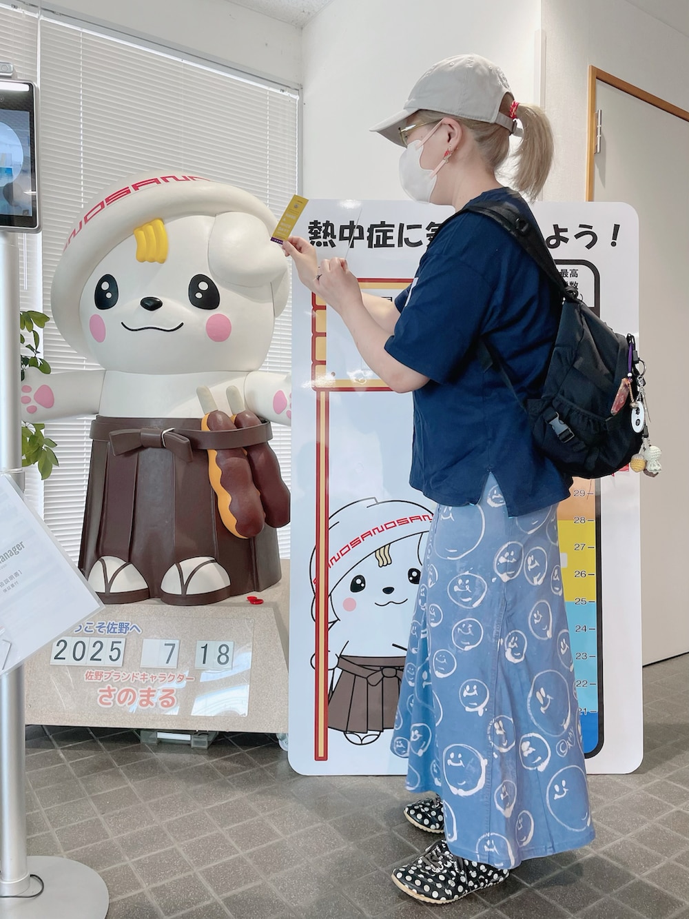 ブルー系のTシャツ/カットソー、ブラック系のバックパック/リュック、ブルー系のデニムスカートを着用したレディースの夏コーディネートの2枚目の写真