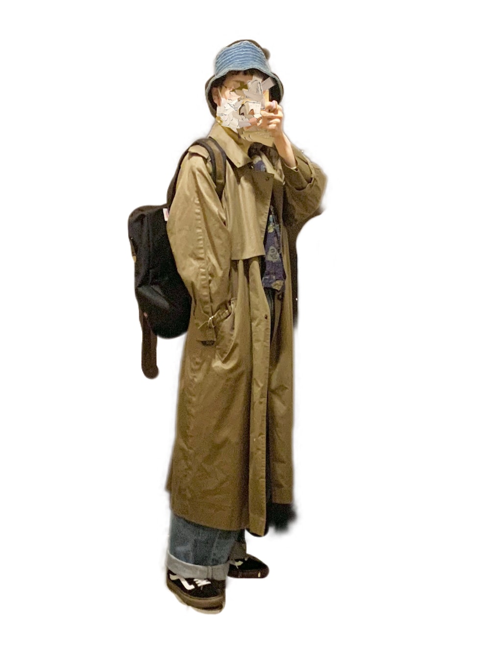 ブラック系のスニーカー、ベージュ系のトレンチコート、ブルー系のデニムパンツを着用したレディースの冬コーディネートの2枚目の写真