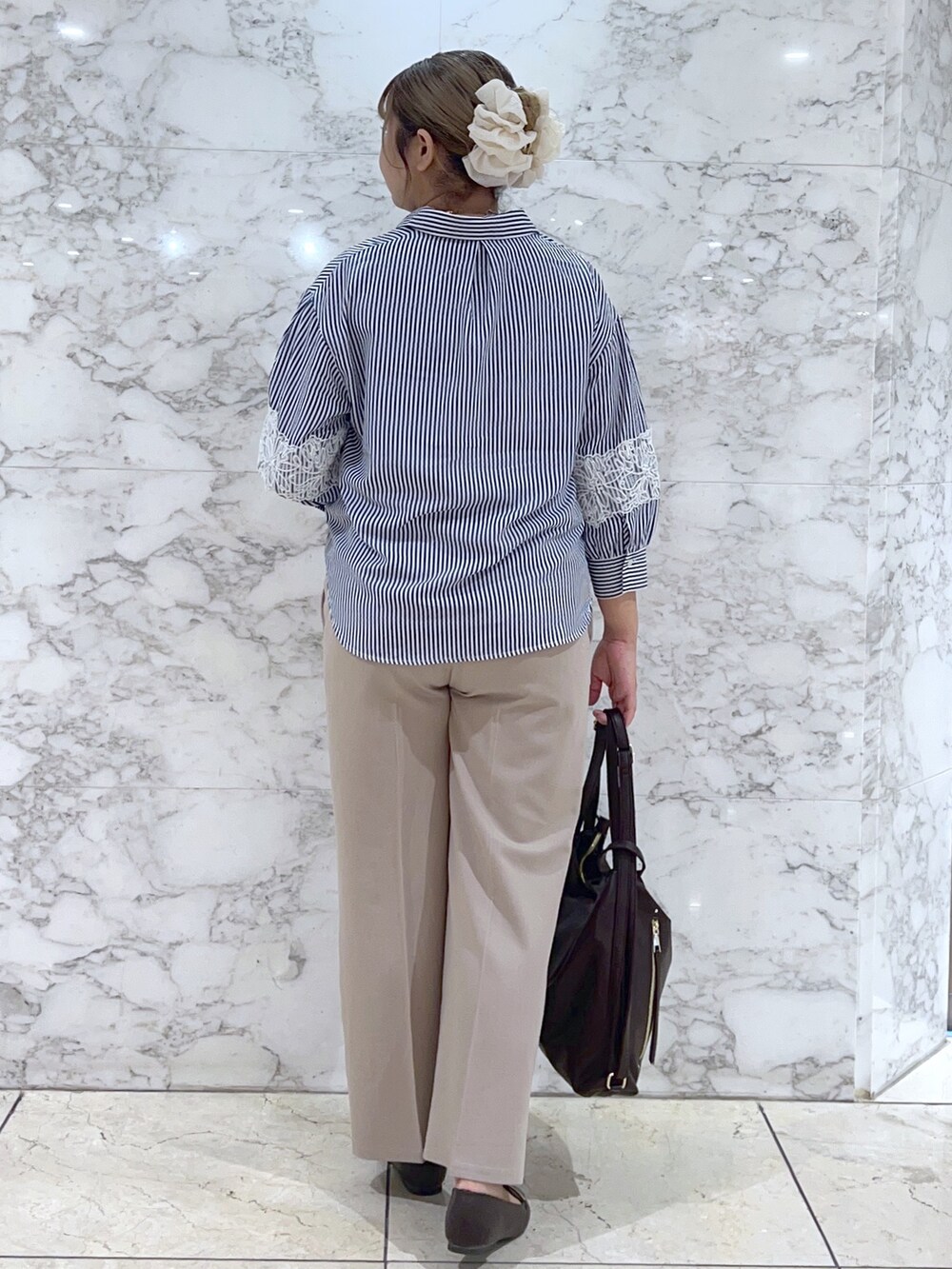 ブルー系のシャツ/ブラウス、ベージュ系のその他パンツ、ブラウン系のショルダーバッグを着用したレディースの夏コーディネートの3枚目の写真