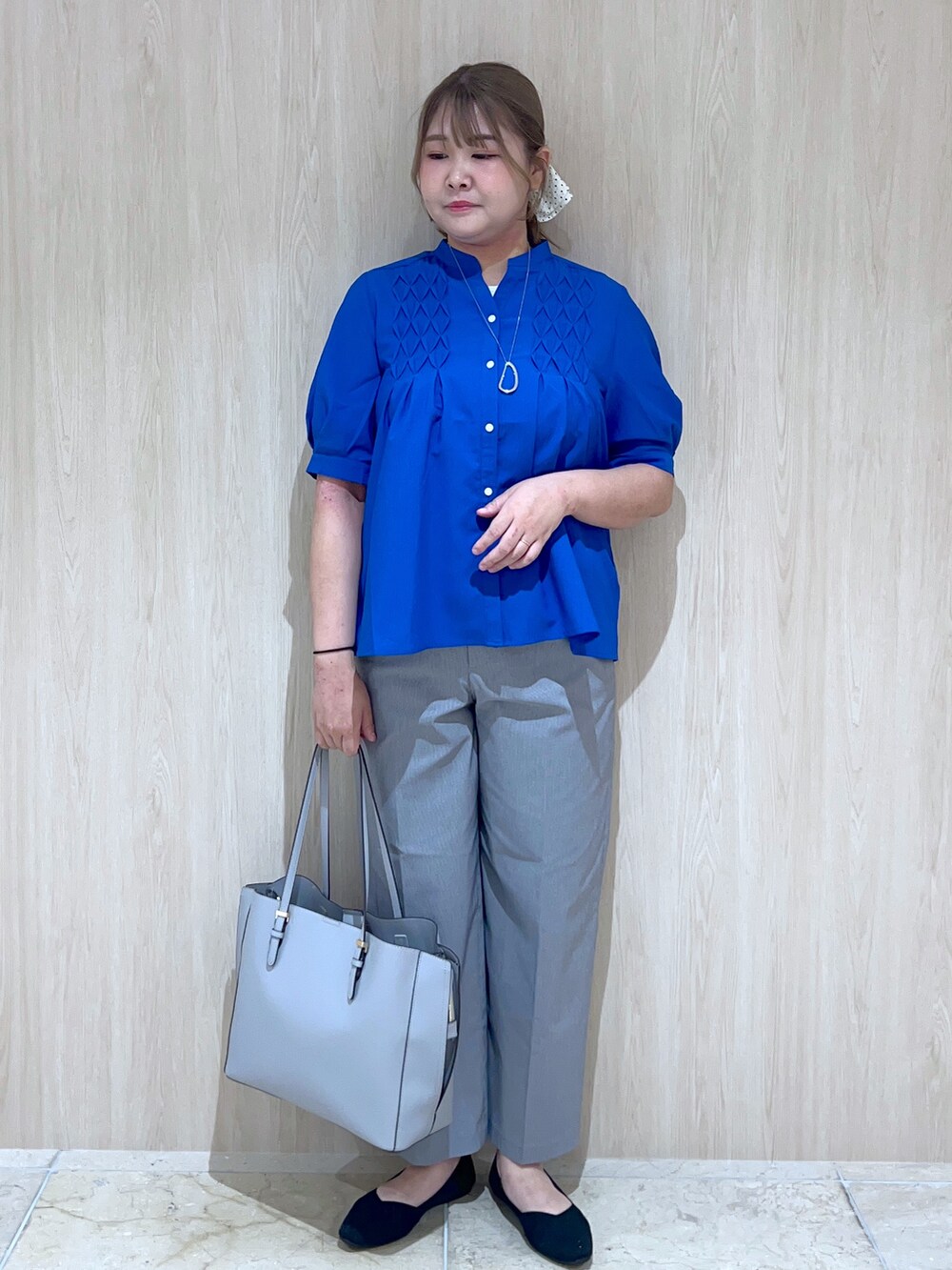 ブルー系のシャツ/ブラウス、グレー系のその他パンツ、ブルー系のトートバッグを着用したレディースの春コーディネートの2枚目の写真
