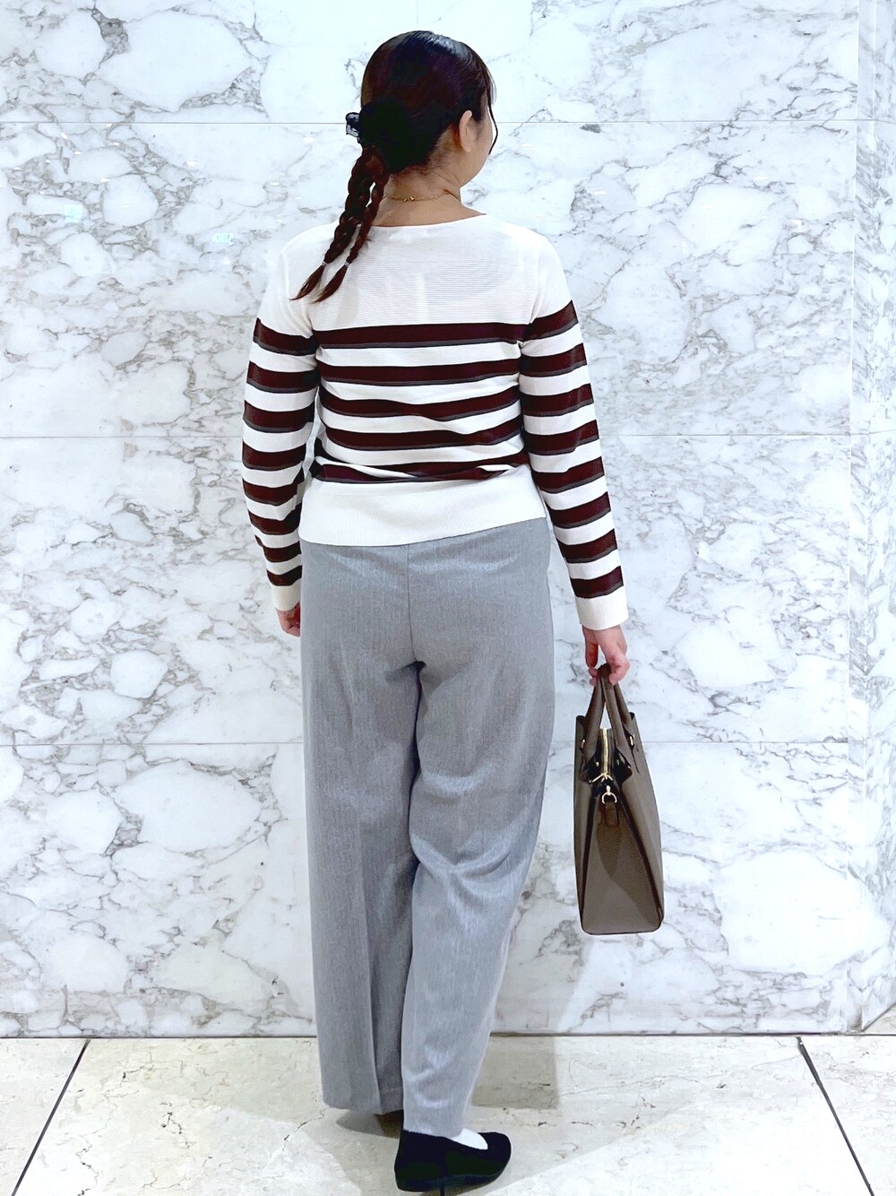 ブラウン系のニット/セーター、グレー系のその他パンツ、ブラウン系のトートバッグを着用したレディースの秋コーディネートの4枚目の写真