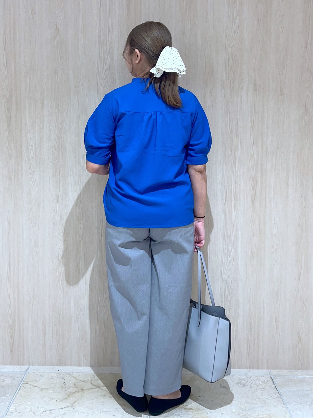 ブルー系のシャツ/ブラウス、グレー系のその他パンツ、ブルー系のトートバッグを着用したレディースの春コーディネートの4枚目の写真