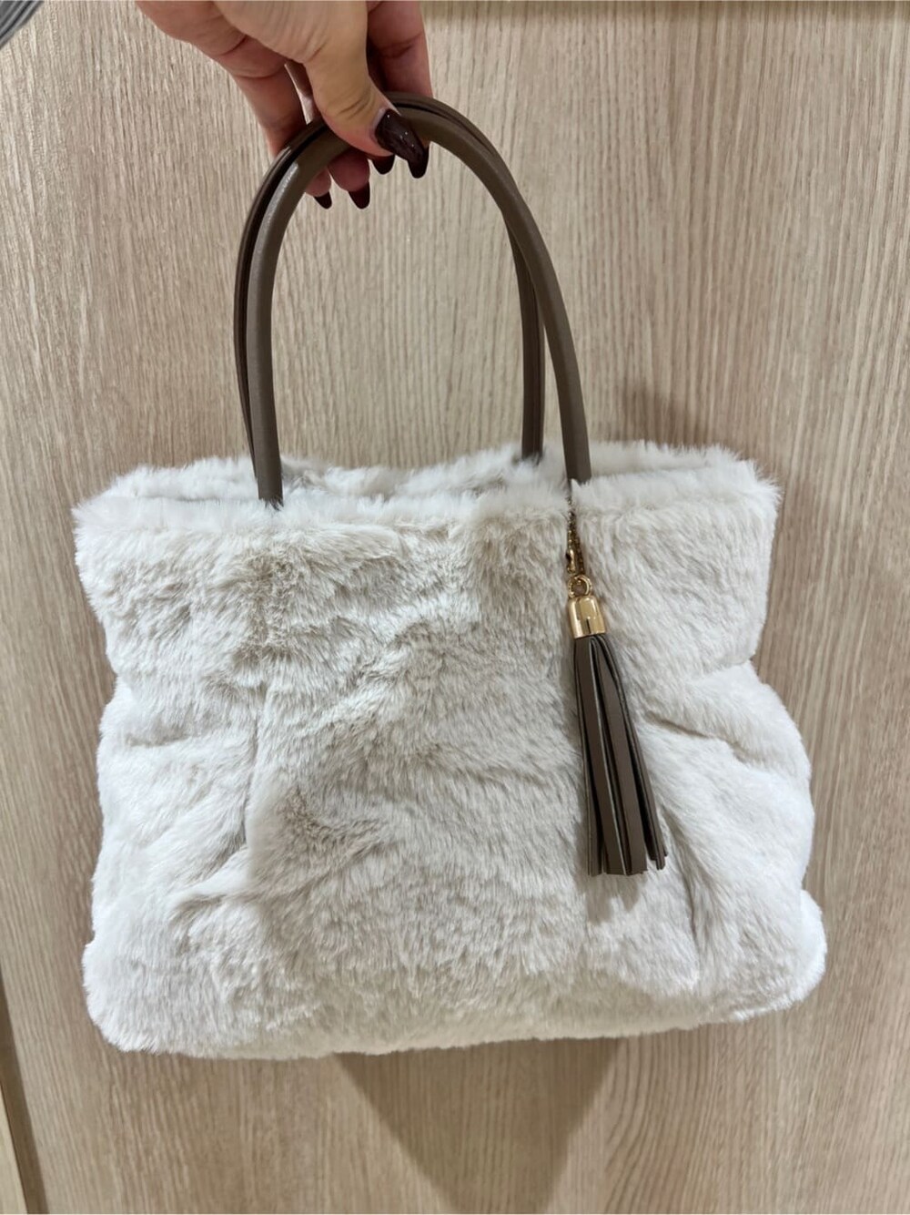 ベージュ系のその他アウター、レッド系のカーディガン/ボレロ、ベージュ系のスカートを着用したレディースの冬コーディネートの6枚目の写真