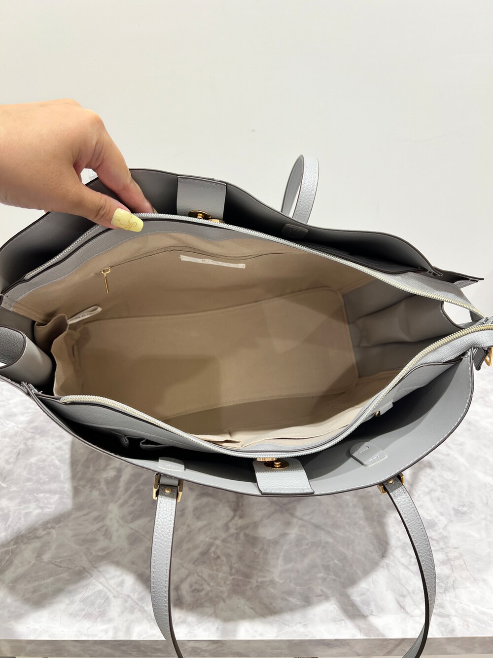 ブルー系のシャツ/ブラウス、グレー系のその他パンツ、ブルー系のトートバッグを着用したレディースの春コーディネートの8枚目の写真