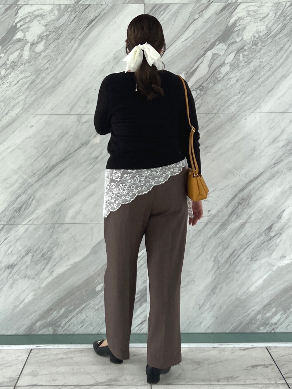 ブラック系のニット/セーター、ブラウン系のその他パンツ、ブラック系のパンプスを着用したレディースの秋コーディネートの5枚目の写真