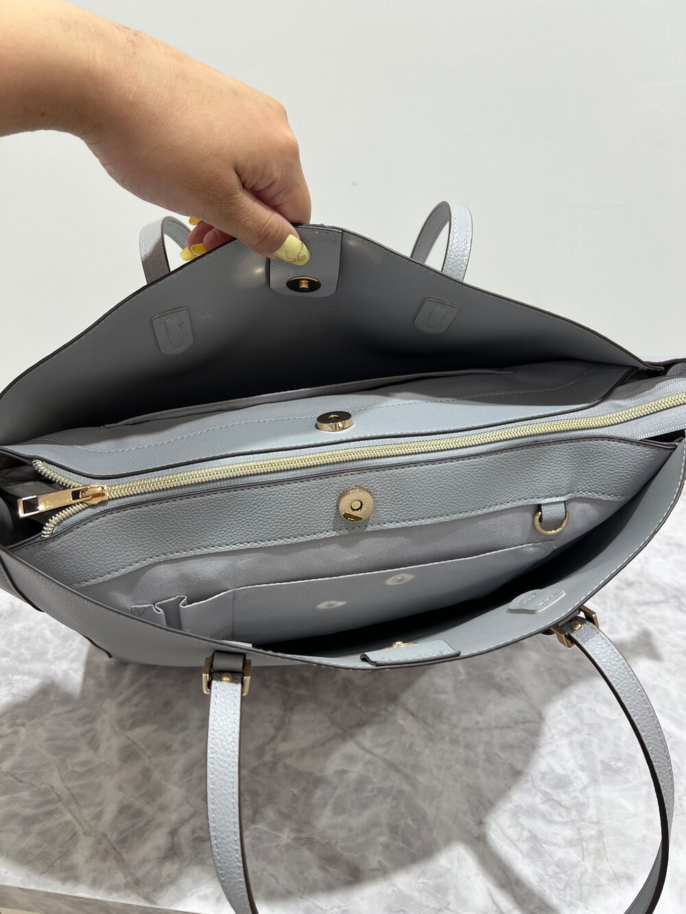ブルー系のシャツ/ブラウス、グレー系のその他パンツ、ブルー系のトートバッグを着用したレディースの春コーディネートの7枚目の写真