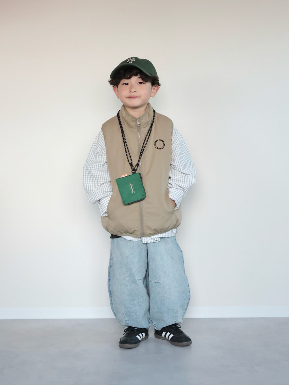 ベージュ系のベスト、ホワイト系のシャツ/ブラウス、ブルー系のデニムパンツを着用したキッズの春コーディネートの4枚目の写真