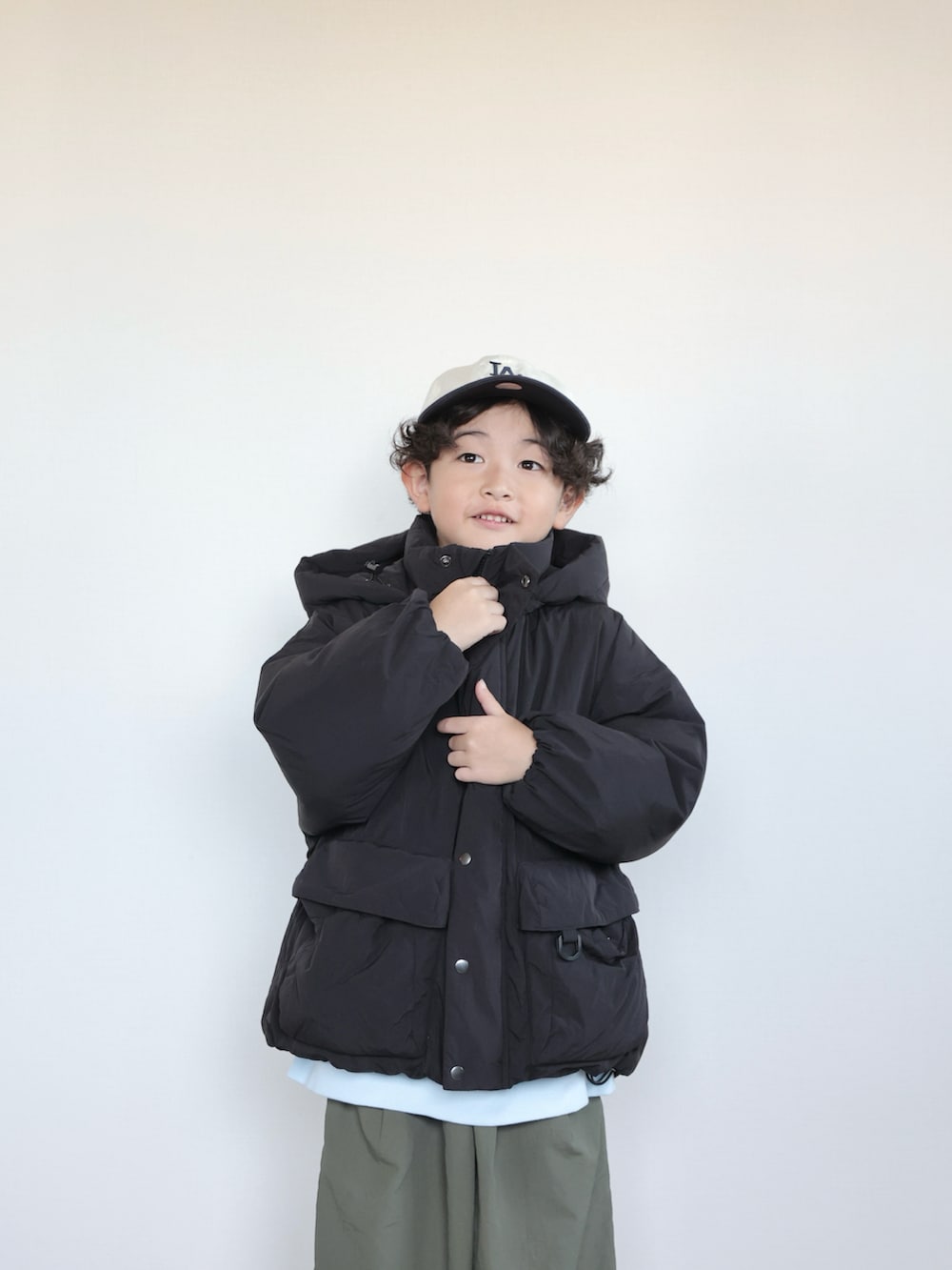 グリーン系のその他パンツ、ブルー系のスウェット、ブラック系のダウンジャケット/コートを着用したキッズの秋コーディネートの3枚目の写真