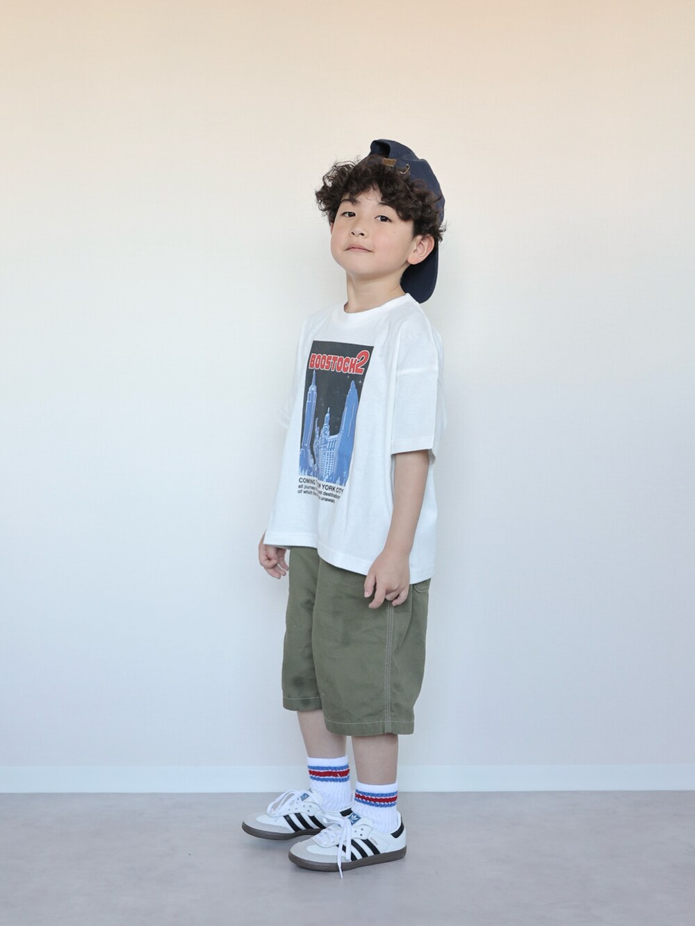 グリーン系のパンツ、ホワイト系のスニーカー、ホワイト系のTシャツ/カットソーを着用したキッズの春コーディネートの4枚目の写真