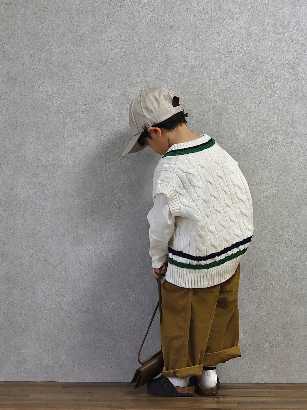 ホワイト系のベスト、ホワイト系のTシャツ/カットソー、ブラウン系のパンツを着用したキッズの秋コーディネートの5枚目の写真