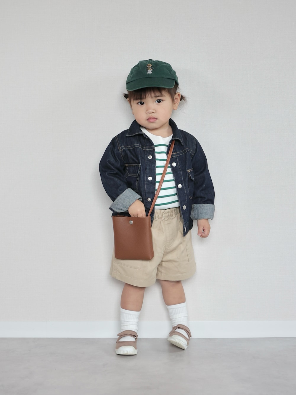 ブルー系のデニムジャケット、ホワイト系のトップス、ベージュ系のパンツを着用したキッズの春コーディネートの4枚目の写真