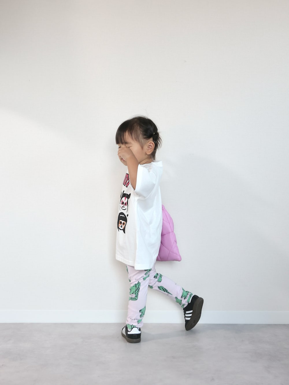 ブラック系のスニーカー、ホワイト系のTシャツ/カットソー、ピンク系のショルダーバッグを着用したキッズの夏コーディネートの3枚目の写真