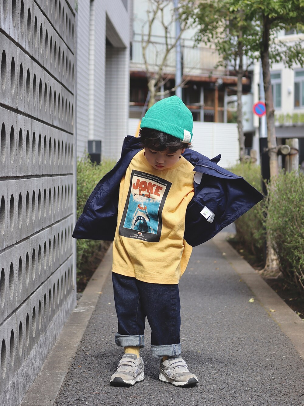 ブルー系のナイロンジャケット、イエロー系のTシャツ/カットソー、ブルー系のデニムパンツを着用したキッズの春コーディネートの2枚目の写真