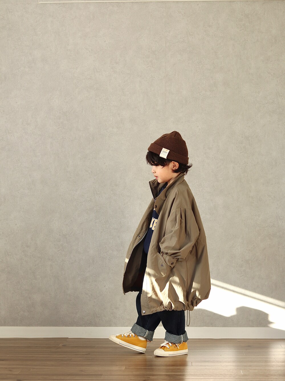 グリーン系のモッズコート、ブルー系のスウェット、ブルー系のデニムパンツを着用したキッズの冬コーディネートの3枚目の写真