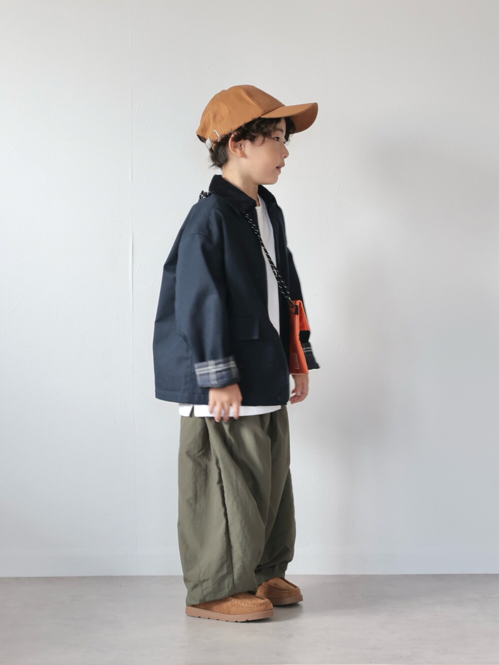 ブルー系のジャケット/アウター、ブラック系のトップス、グリーン系のその他パンツを着用したキッズの秋コーディネートの2枚目の写真