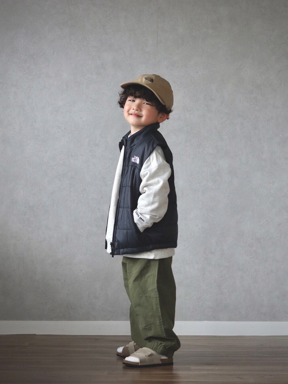 グリーン系のダウンジャケット/コート、ホワイト系のスウェット、ホワイト系のシャツ/ブラウスを着用したキッズの春コーディネートの4枚目の写真