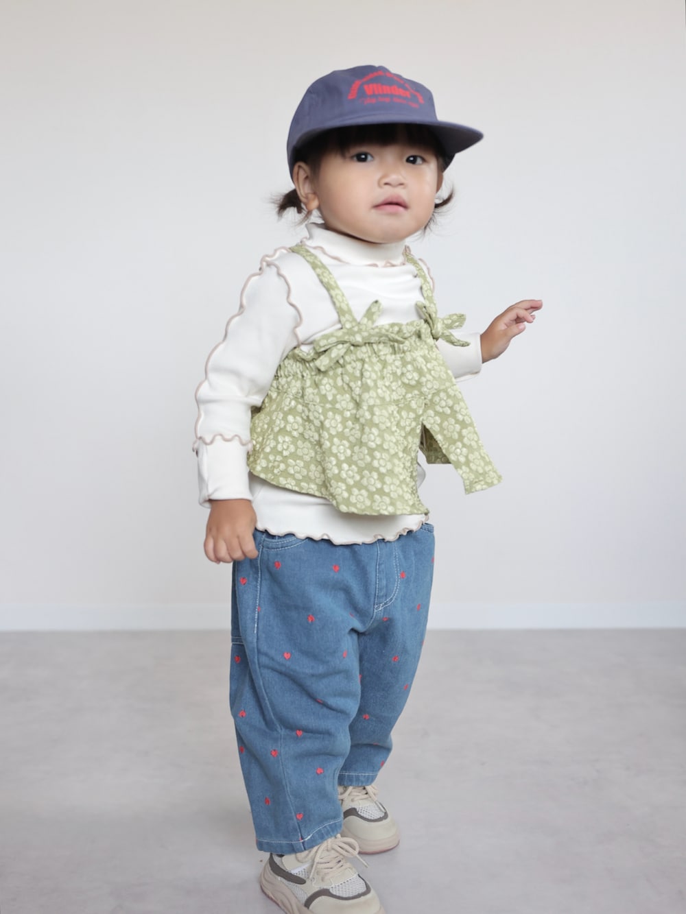 ベージュ系のスニーカー、グリーン系のTシャツ/カットソー、ブルー系のデニムパンツを着用したキッズの夏コーディネートの5枚目の写真