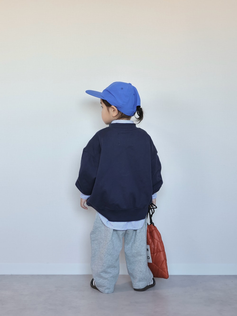 グレー系のスウェットパンツ、ブラック系のスニーカー、ブルー系のスウェットを着用したキッズの冬コーディネートの3枚目の写真
