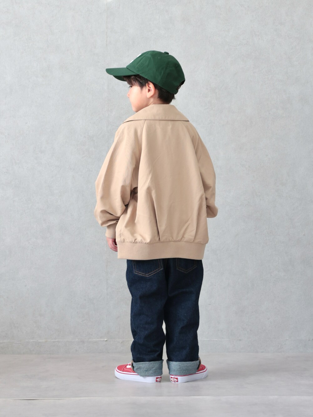 ブラウン系のブルゾン、グレー系のTシャツ/カットソー、ブルー系のデニムパンツを着用したキッズの春コーディネートの4枚目の写真