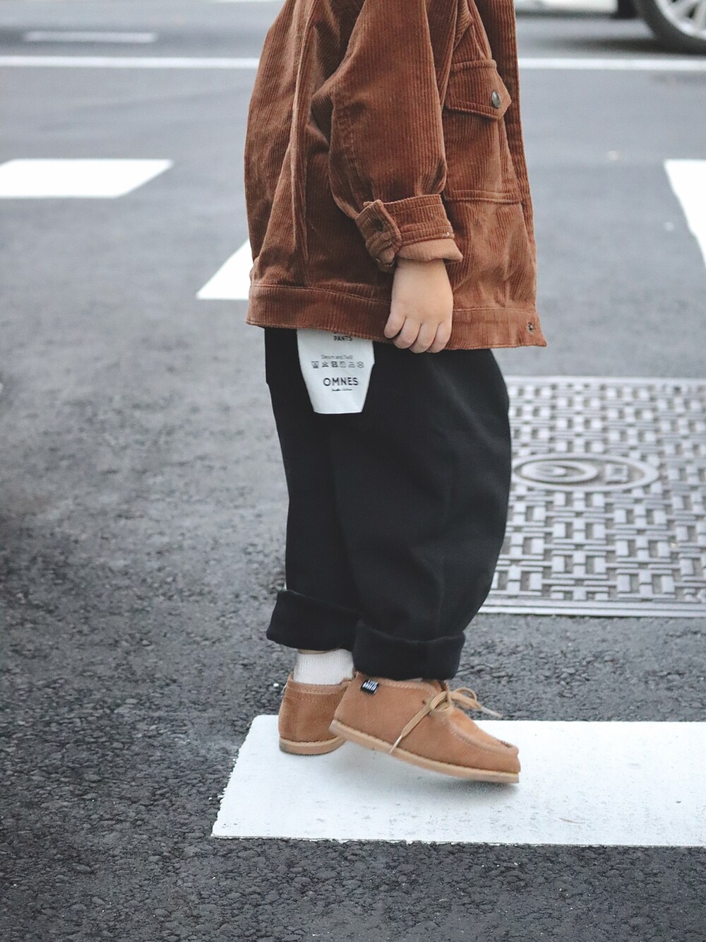 ブラウン系のブルゾン、ホワイト系のシャツ/ブラウス、ブラック系のその他パンツを着用したキッズの秋コーディネートの4枚目の写真