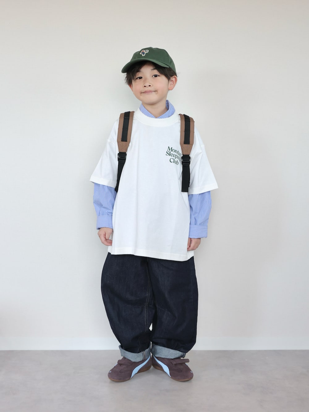 ホワイト系のTシャツ/カットソー、ブラウン系のバックパック/リュック、ブラウン系のスニーカーを着用したキッズの春コーディネートの2枚目の写真