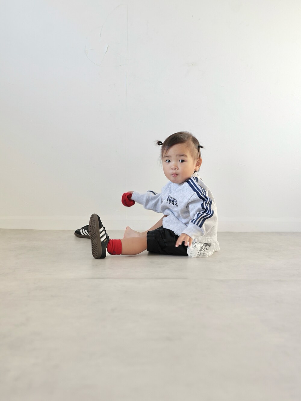 グレー系のスウェット、ブラック系のスカート、ブラック系のスニーカーを着用したキッズの秋コーディネートの5枚目の写真