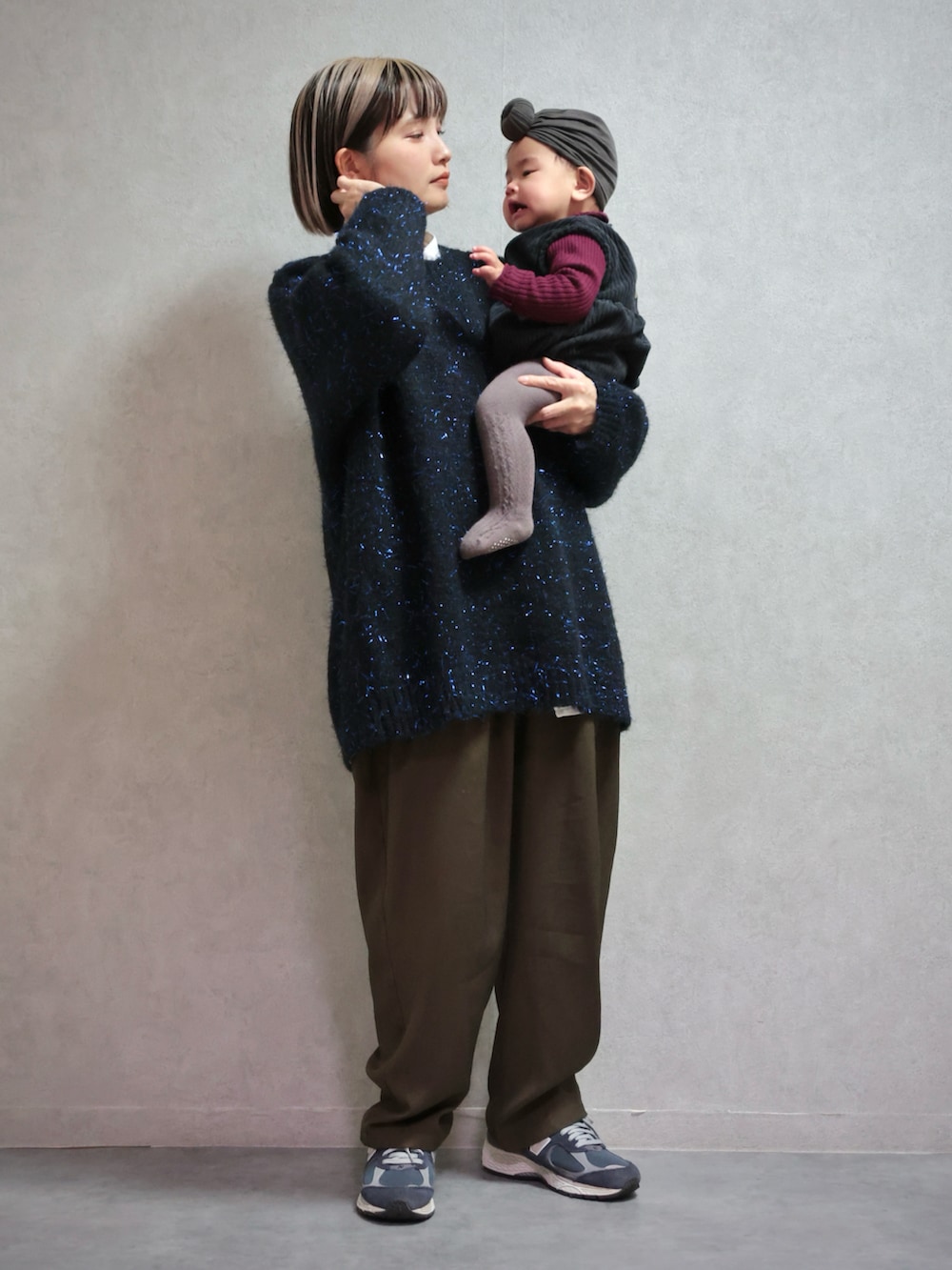 ブラック系のニット/セーター、グリーン系のスラックス、ブルー系のスニーカーを着用したキッズの冬コーディネートの2枚目の写真