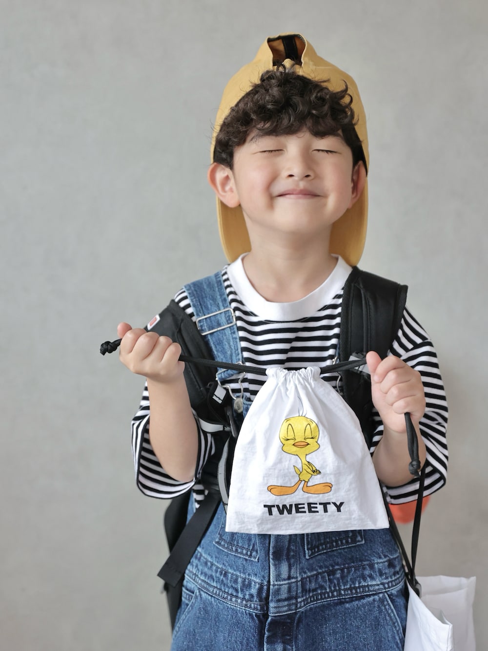 ブラック系のTシャツ/カットソー、ブルー系のサロペット/オーバーオール、ブラック系のスニーカーを着用したキッズの春コーディネートの3枚目の写真