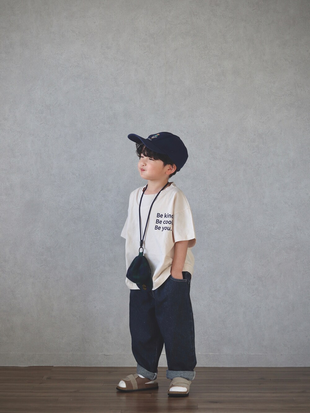 ベージュ系のトップス、ブルー系のデニムパンツ、ベージュ系のサンダルを着用したキッズの春コーディネートの5枚目の写真