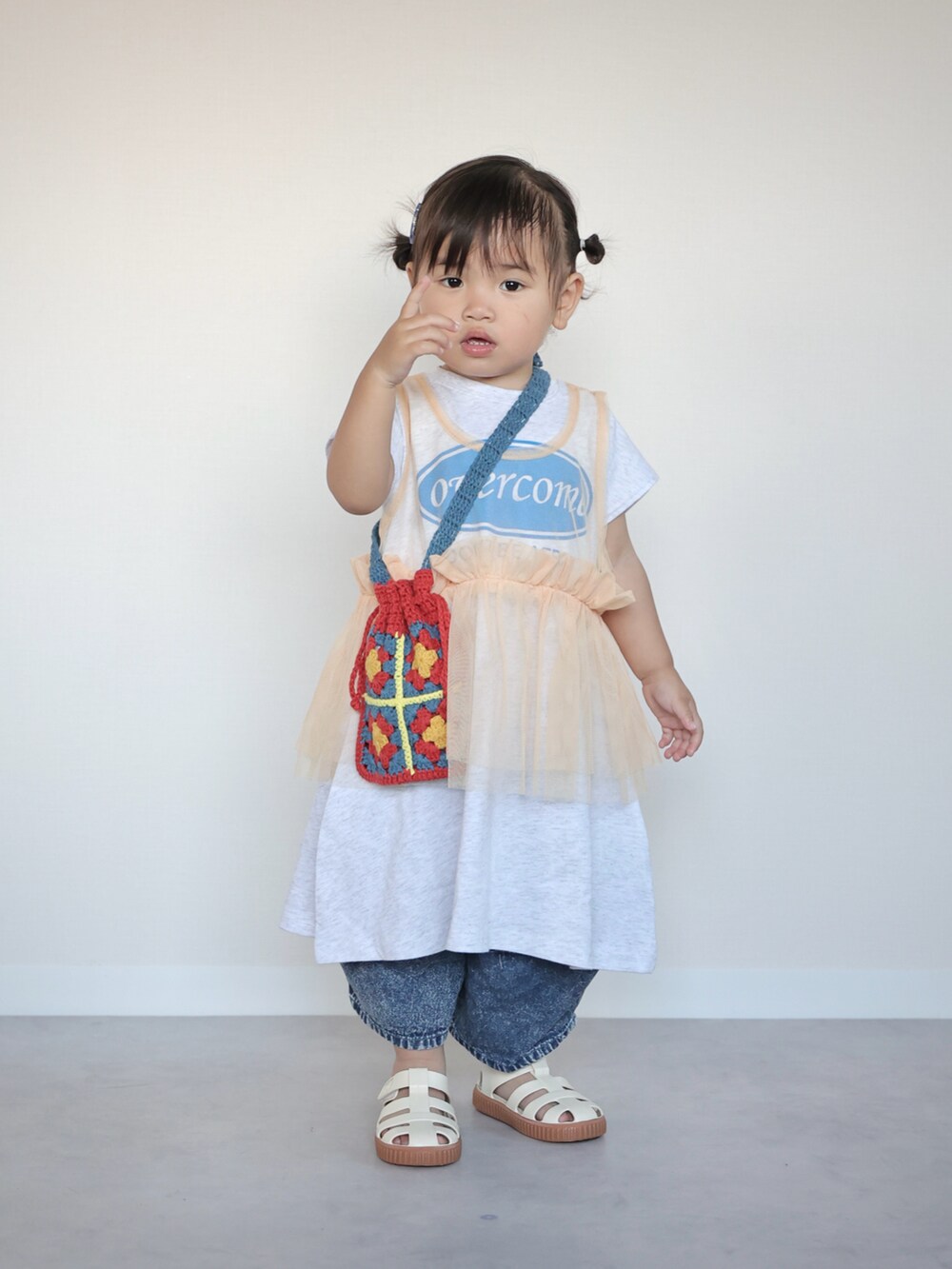 ホワイト系のワンピース、ブルー系のデニムパンツ、ホワイト系のサンダルを着用したキッズの夏コーディネートの4枚目の写真