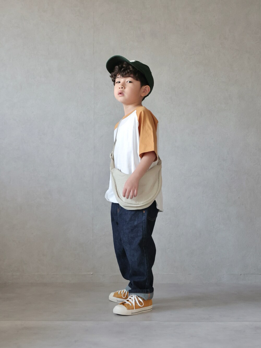 イエロー系のTシャツ/カットソー、ブルー系のデニムパンツ、イエロー系のスニーカーを着用したキッズの春コーディネートの3枚目の写真